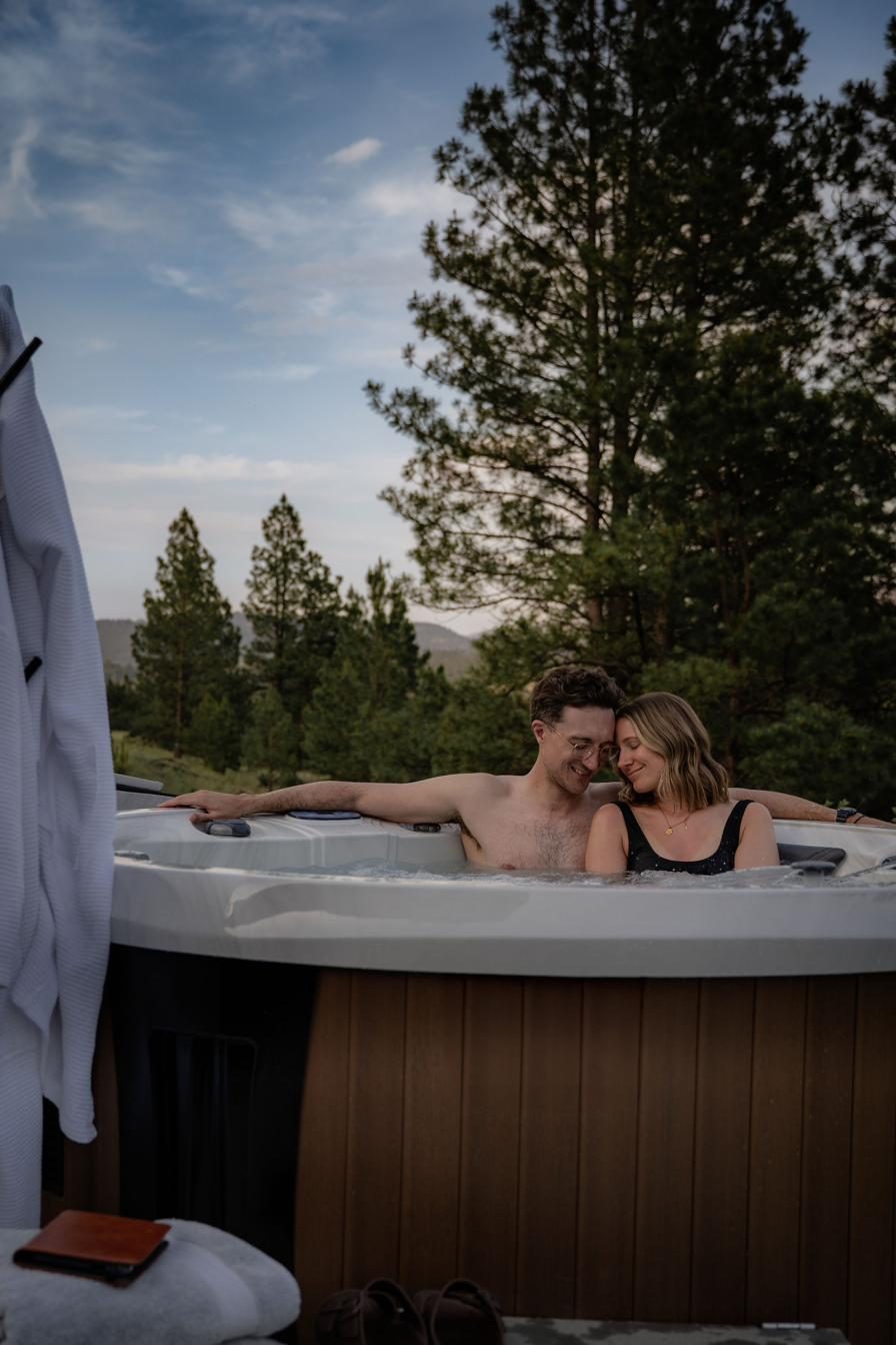Couple relaxing in the hot tub at sunset