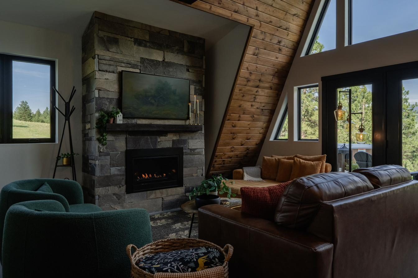 Living room with stone gas fireplace and vaulted A-frame ceiling